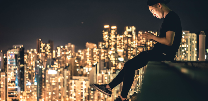 guy sitting on the side of the roof with a phone and using Yolla