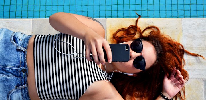 woman lying and listening to music on iphone