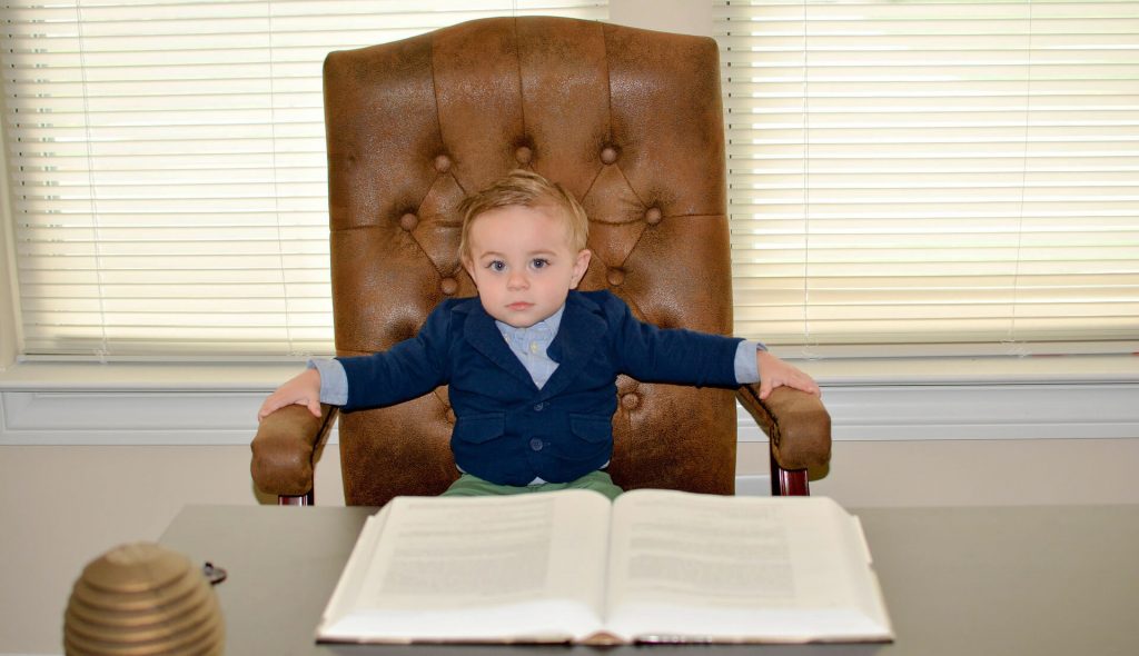 a kid sitting on a big leather office chair