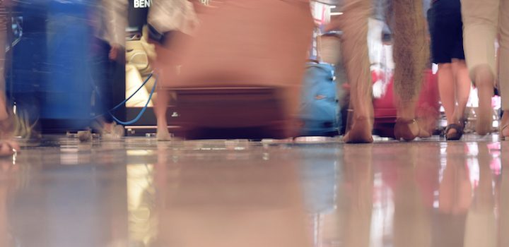a blurred image with people running around in an airport