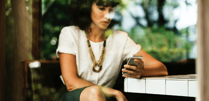 woman sitting at the table with iphone